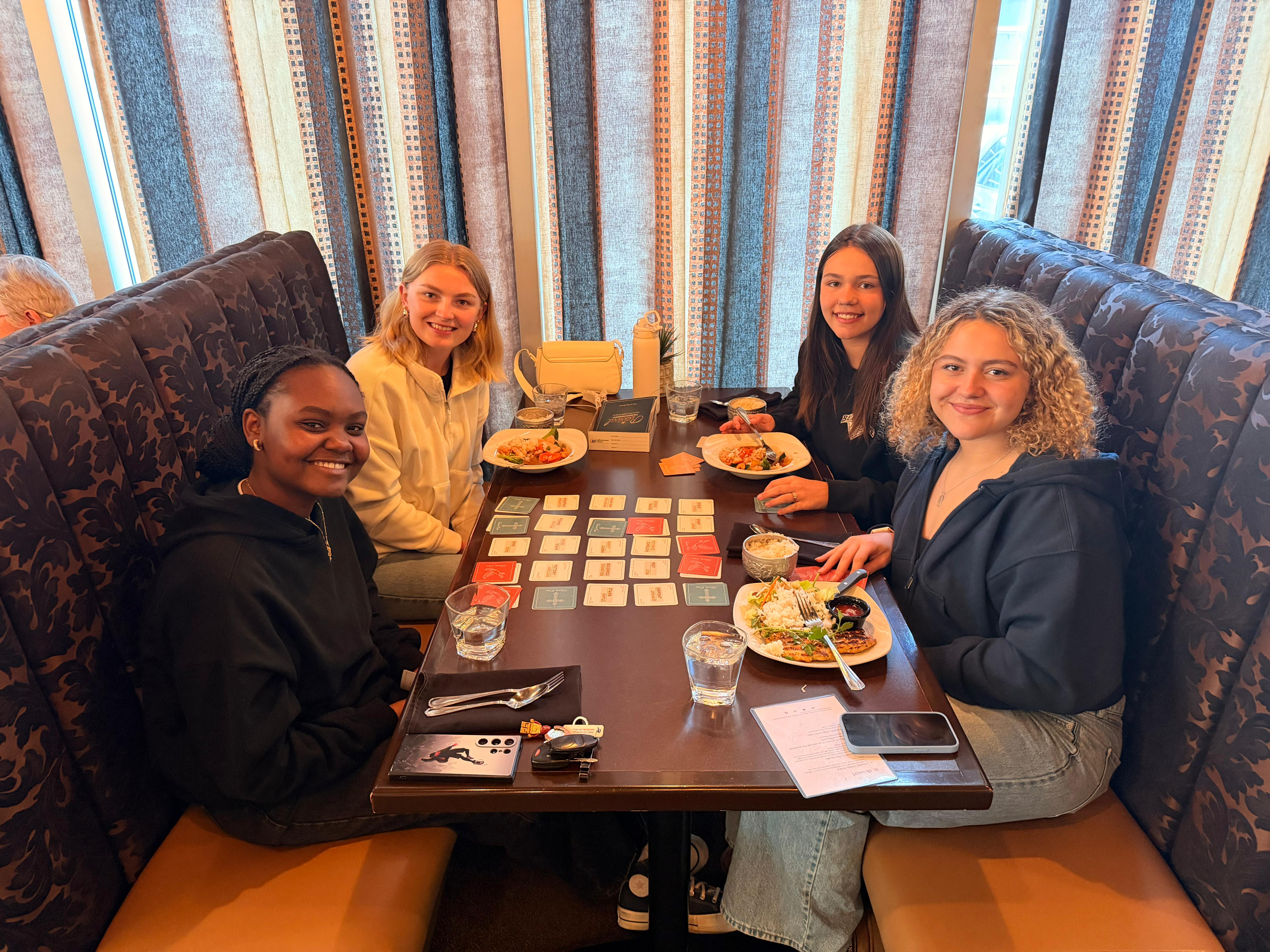 Four friends playing Revival over lunch at a restaurant